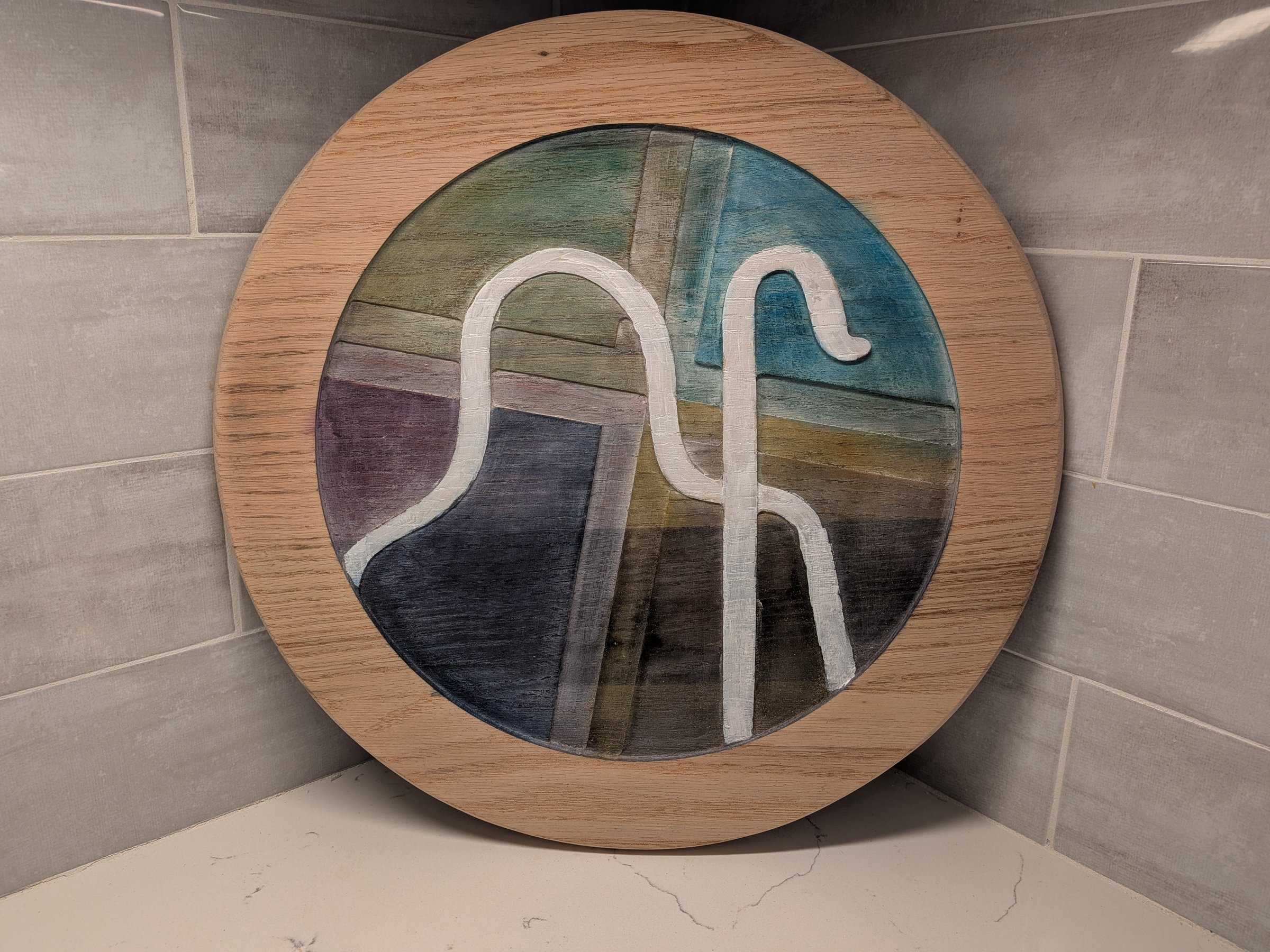Round painted wood panel with a the Christ our Shepherd church logo built from reclaimed church pews
